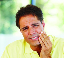 Portrait of middle aged man suffering from toothache at home